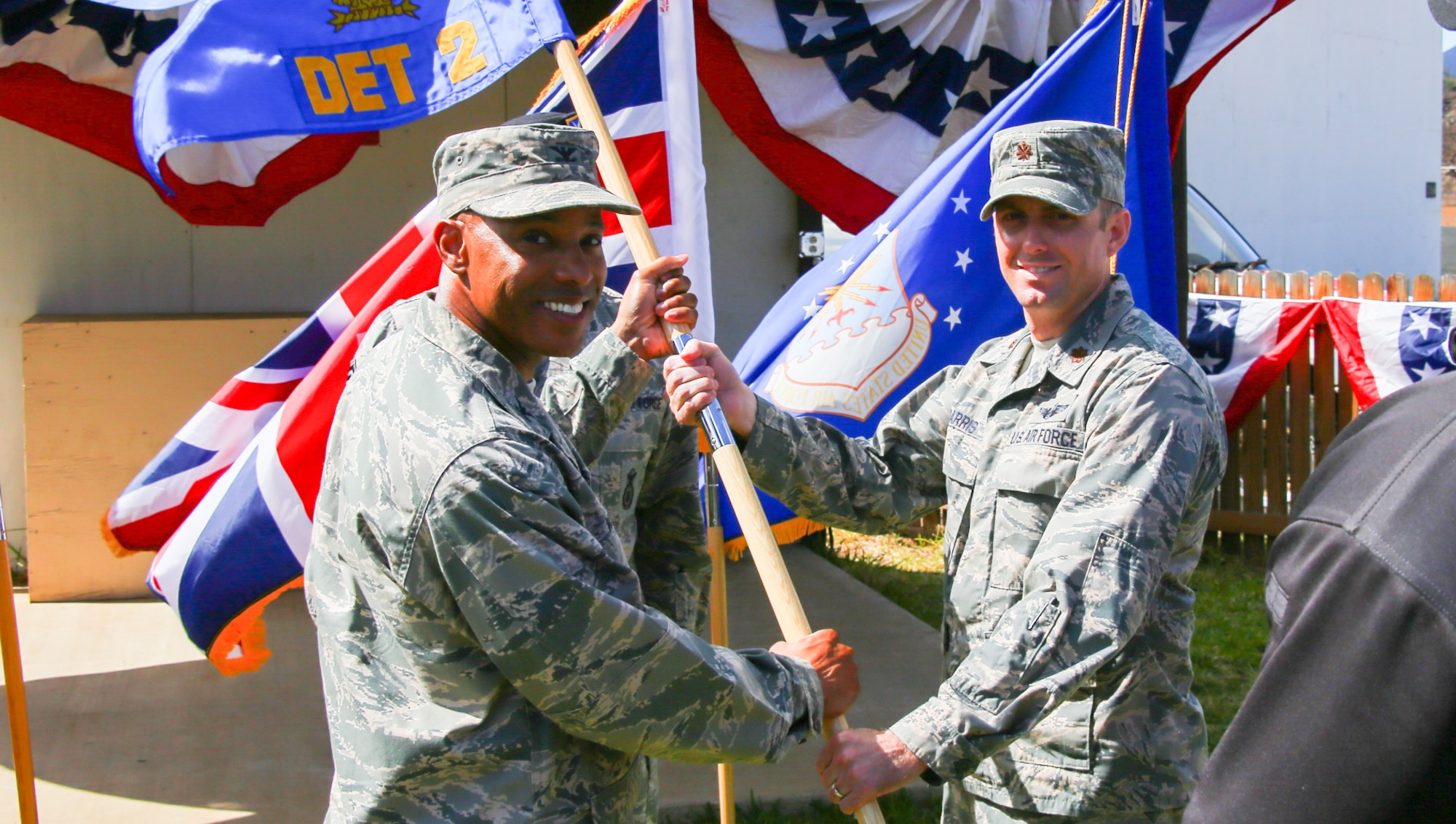 Col Kevin Williams, 45th Mission Support group commander, presents Maj Adam Harris, 45th Detachment 2 commander, with the guidon during an assumption of command ceremony July 25th, 2017, on Ascension Island. Maj Harris has previously served under the Wing's Detachment 3 as the Orion Flight Division Chief and previously as the Wing's Director of Staff. (U.S. Air Force photo) 
