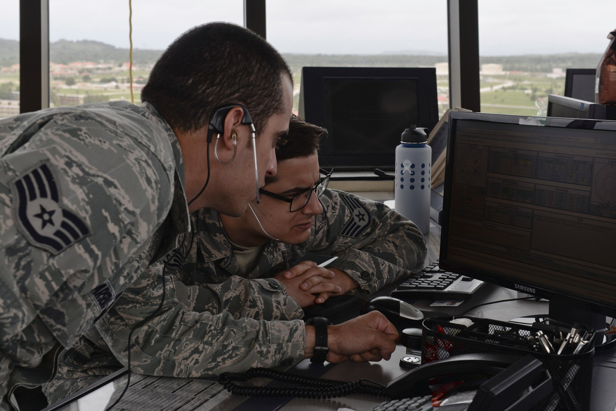 U.S. Air Force Staff Sgt. Nicholas Barsenas, 36th Operation Support Squadron air traffic controller (left), and Staff Sgt. Nicholas Luciano, review flight information inside the updated tower July 17, 2017, at Andersen Air Force Base, Guam. Air traffic control Airmen assigned to the 36th Operation Support Squadron began work in the new tower cab here June 30 after spending almost three months working in the mobile tower unit on the flightline. (U.S. Air Force photo by Airman 1st Class Gerald Willis)
