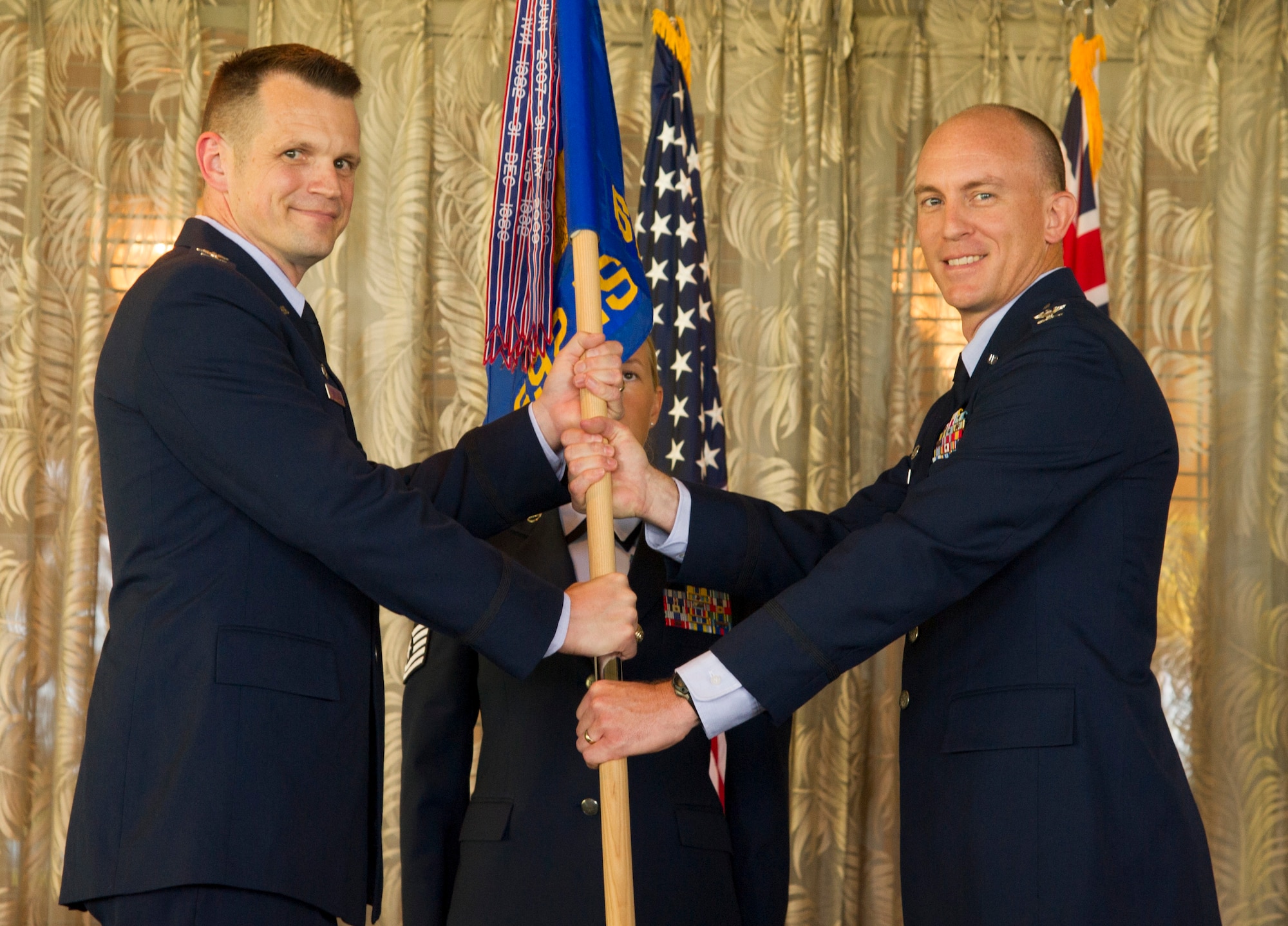 Col. Jason Brown, 480th Intelligence, Surveillance and Reconnaissance Wing commander, gives the group flag Col. David Dengler,  incoming commander of the 692nd Intelligence, Surveillance and Reconnaissance Group, during the 692 ISRG Change of Command Ceremony, Joint Base Pearl Harbor-Hickam, Hawaii, July 17, 2017. The 692 ISRG, headquartered at Joint Base Pearl Harbor-Hickam, Hawaii, processes, exploits and disseminates ISR data collected by U-2, Predator and Global Hawk aircraft. (U.S. photo by Tech. Sgt. Heather Redman)