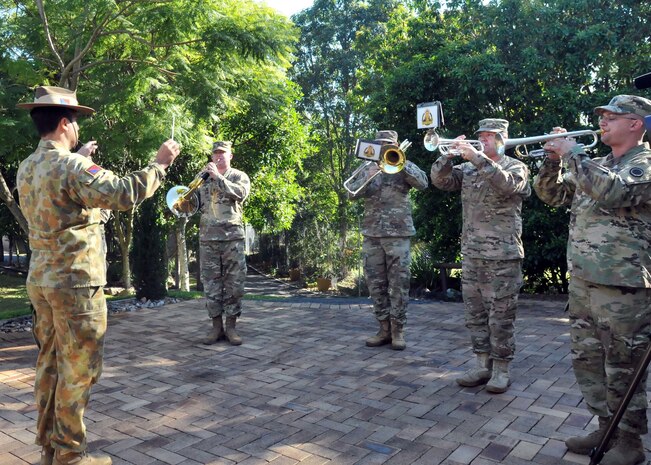 Warrant Officer 1st Class Hemi Anning, Band of the 1st Regiment, Royal Regiment of Australian Artillery, conducts U.S. Army Sgt. 1st Class Todd Borges, music performance team leader, Sgt. Mark Koehl, an army musician, Staff Sgt. Brandon Egner, assistant music performance leader, and Staff Sgt. Brian Adamski, operations noncommissioned officer, all of American’s First Corps Army Band, in playing the “Star Spangled Banner” at a memorial service in Enoggeraa, Australia, July 17, 2017. The band was supporting a monthly memorial service organized by the veteran group, Dads Army. (U.S. Army photo by Sgt. Debrah Sanders, 366th Mobile Public Affairs Detachment)