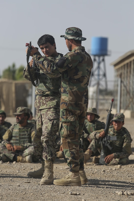 An Afghan National Army soldier with the Helmand Province Regional Military Training Center instructs a soldier with 2nd Kandak, 4th Brigade, 215th Corps on how to properly handle an M16A2 rifle during squad attacks at Camp Shorabak, Afghanistan, June 19, 2017. Approximately 600 soldiers with the unit graduated from an eight-week operational readiness cycle July 24 with assistance from U.S. Marines assigned to Task Force Southwest. The ORC is designed to enhance the students’ warfighting capabilities to help defeat insurgency throughout the region. (U.S. Marine Corps photo by Sgt. Lucas Hopkins)