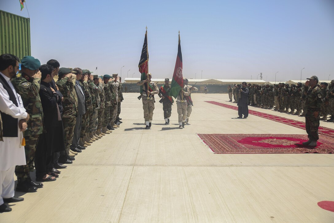 The Afghan National Army 215th Corps color guard marches the Afghan national colors past Helmand Province key leaders and soldiers with 2nd Kandak, 4th Brigade, 215th Corps during a graduation ceremony at Camp Shorabak, Afghanistan, July 24, 2017. The 2nd Kandak, 4th Brigade completed an eight-week operational readiness cycle at the Helmand Regional Military Training Center, an eight-week course led by ANA instructors with assistance from U.S. Marine advisors with Task Force Southwest.  The ORC is designed to enhance its students’ infantry skills in order to create an enduring and capable force to combat insurgency in the region. (U.S. Marine Corps photo by Sgt. Lucas Hopkins)