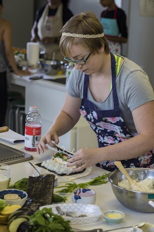 Chandra Moudy, a Marine Corps Air Station Iwakuni resident, rolls sushi during a Japanese cooking class at Santopia in Otake, Japan, July 25, 2017. Air station residents received a demonstration followed by hands-on experience with preparing and cooking Japanese dishes. The class gave a common purpose for participants to work together and learn Japanese cooking skills that can be utilized within their own homes. (U.S. Marine Corps photo by Cpl. Joseph Abrego)