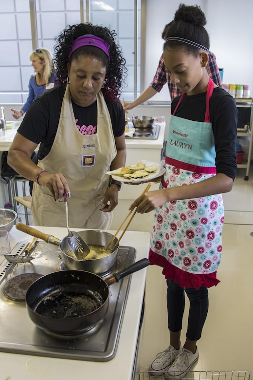 Elizabeth Scott, left, and Lauryn Scott, Marine Corps Air Station Iwakuni residents, cook tempura during a Japanese cooking class at Santopia in Otake, Japan, July 25, 2017. During the class, participants learned new techniques to aid in their cooking such as using mayonnaise to help tempura batter stick to vegetables. The class gave a common purpose for participants to work together and learn Japanese cooking skills that can be utilized within their own homes.  (U.S. Marine Corps photo by Cpl. Joseph Abrego)