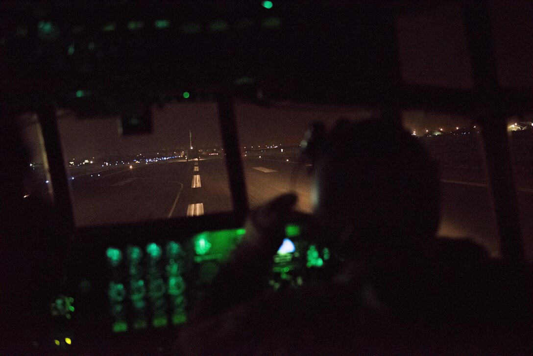 A pilot with the 737th Expeditionary Airlift Squadron looks out the window of a C-130H Hercules as the aircraft takes the runway behind another C-130 at an undisclosed location in Southwest Asia, July 14, 2017. Air National Guardsmen and their aircraft, deployed in support of Combined Joint Task Force – Operation Inherent Resolve, execute daily airlift missions out of one of the busiest air bases in the U.S. Air Forces Central Command area of responsibility. (U.S. Air Force photo by Tech. Sgt.  Jonathan Hehnly)