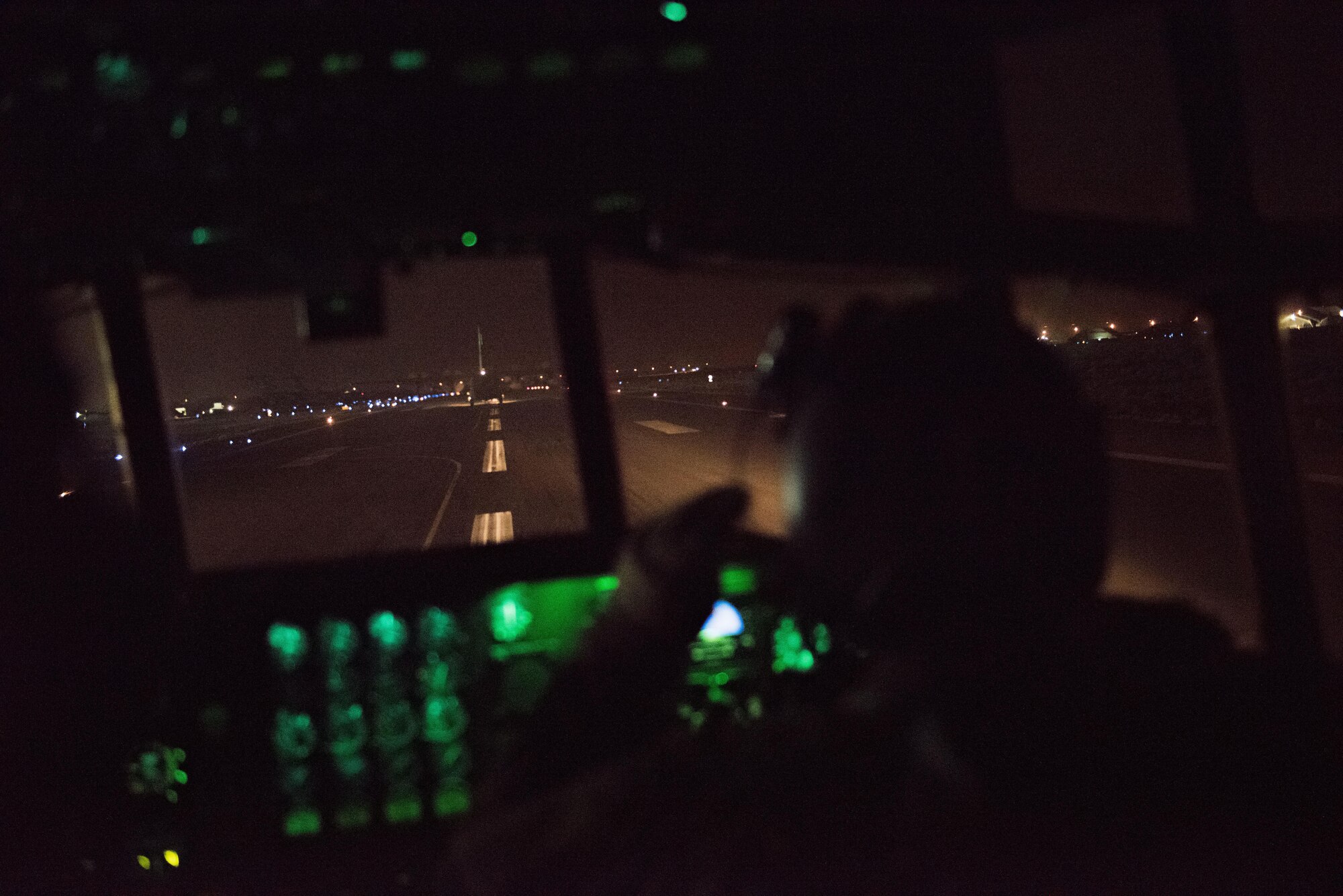 A pilot with the 737th Expeditionary Airlift Squadron looks out the window of a C-130H Hercules as the aircraft takes the runway behind another C-130 at an undisclosed location in Southwest Asia, July 14, 2017. Air National Guardsmen and their aircraft, deployed in support of Combined Joint Task Force – Operation Inherent Resolve, execute daily airlift missions out of one of the busiest air bases in the U.S. Air Forces Central Command area of responsibility. (U.S. Air Force photo by Tech. Sgt.  Jonathan Hehnly)