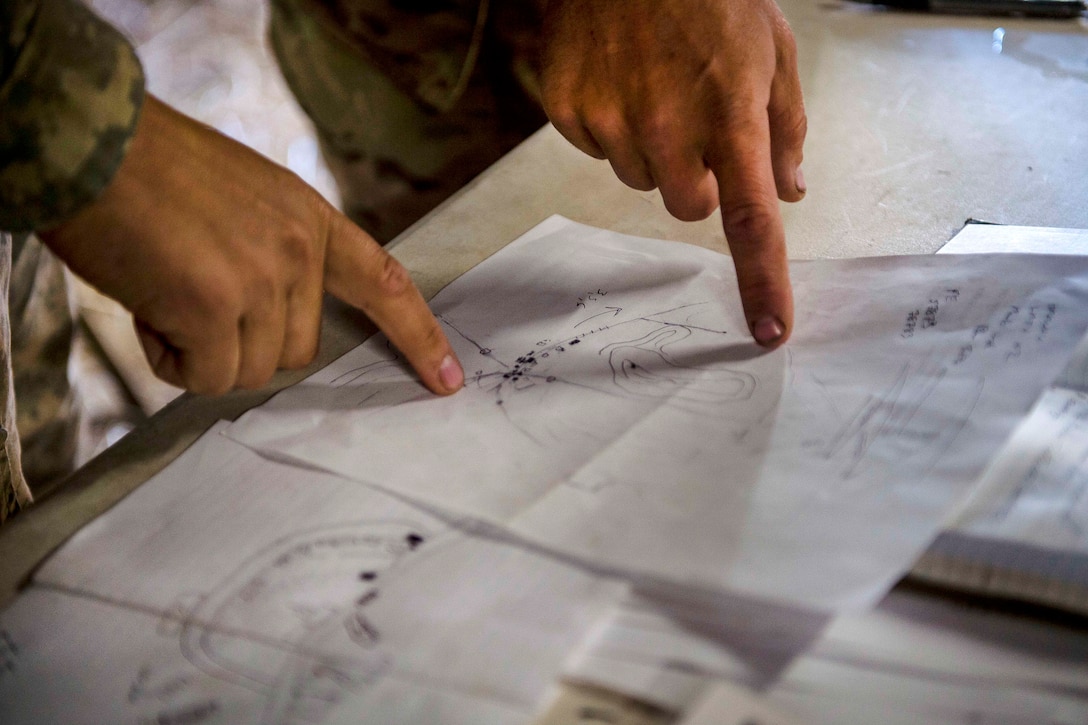 Soldiers point to key objectives on a map before participating in a combat training exercise at Fort Hunter Liggett, Calif., July 22, 2017. The soldiers are military police officers. Army Reserve photo by Master Sgt. Michel Sauret