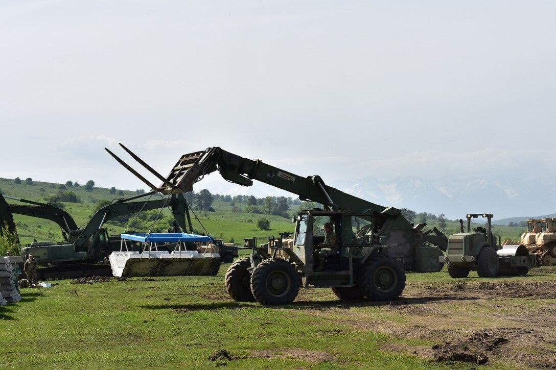 Army Spc. George Flowers, 926th Engineer Brigade, forklifts a concrete mat as part of Resolute Castle 2017 at the Joint National Training Center, Cincu, Romania. DLA-provided materials such as stones, concrete and lumber were used for Resolute Castle 2017 projects. The concrete mat is used as a foundation for roads in wet areas and low-water crossings. 