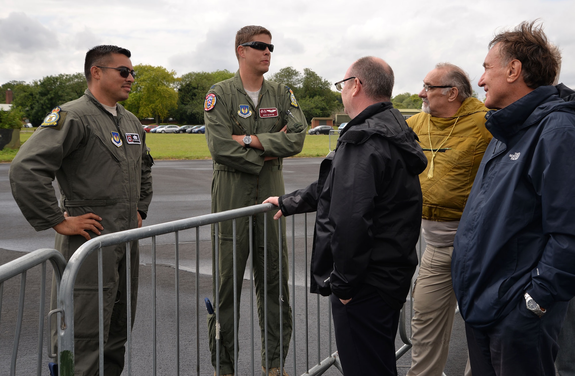 U.S. Air Force Staff Sgt. Ernesto Riojas, left, 100th Aircraft Maintenance Squadron flying crew chief, and U.S. Air Force Capt. Ben Martin, 100th Operations Group KC-135 Stratotankerpilot, talk to members of the crowd at the RAF Marham Friends and Families Day event July 20, 2017, at Marham, England. Team Mildenhall supported the event with static displays of a KC-135 Stratotanker and a CV-22 Osprey. (U.S. Air Force photo by Karen Abeyasekere)