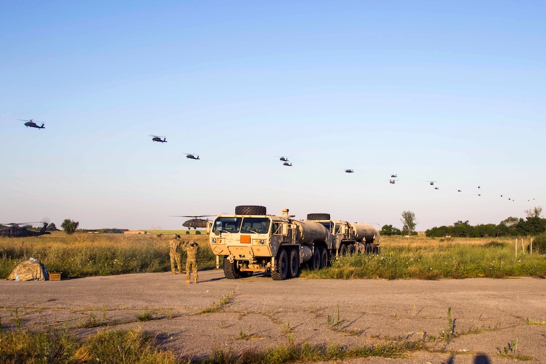 UH-60 Black Hawk and CH-47 Chinook helicopters arrive to pick-up U.S., Greek and Canadian troops before participating in night air assault training during exercise Swift Response at Bezmer Air Base, Bulgaria, July 21, 2017. The exercise is part of the Saber Guardian 17 exercise. The helicopter crews are assigned to the 10th Combat Aviation Brigade. Army photo by Spc. Thomas Scaggs