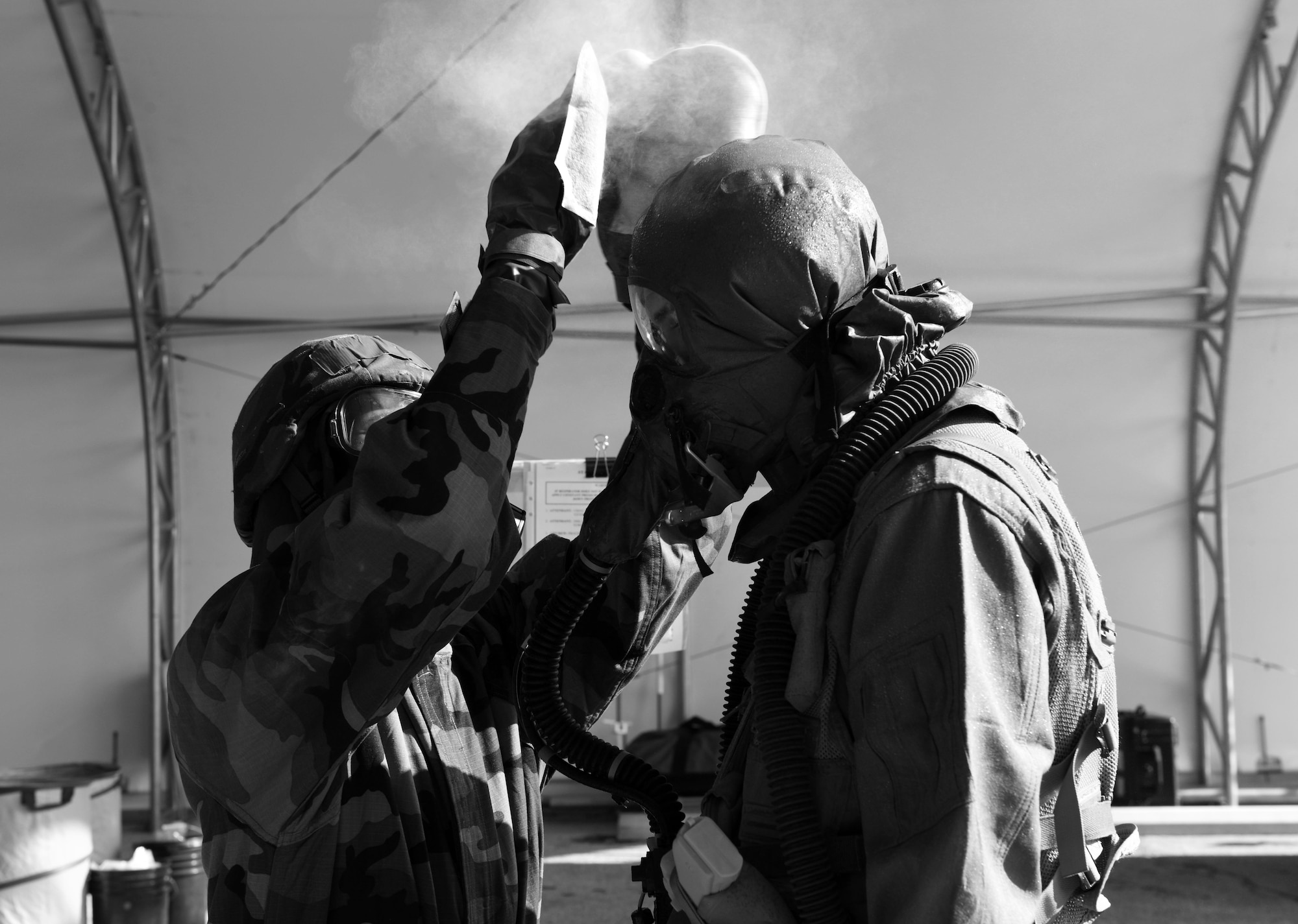 An aircrew flight equipment Airman uses M295 mitts to simulate removing contamination from an aircrew member during the Aircrew Contamination Control Area process as part of exercise Toxic Arch on at Scott Air Force Base, Ill., July 19. The M295 mitts are used to transfer as much charcoal to the aircrew member and equipment as possible. (U.S. Air Force photo by Tech. Sgt. Terri Paden)

