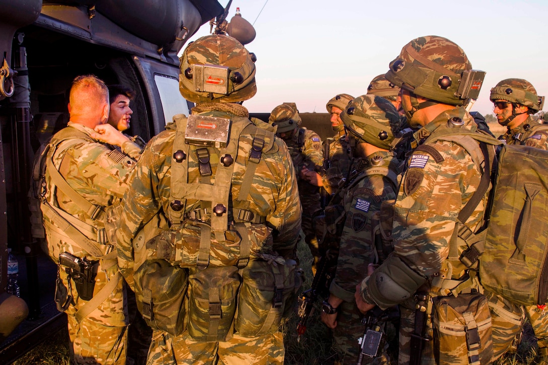 Army helicopter crew members, left, give a safety brief to Greek soldiers before participating in night air assault training during exercise Swift Response at Bezmer Air Base, Bulgaria, July 21, 2017. The exercise is part of Saber Guardian 17. Army photo by Spc. Thomas Scaggs