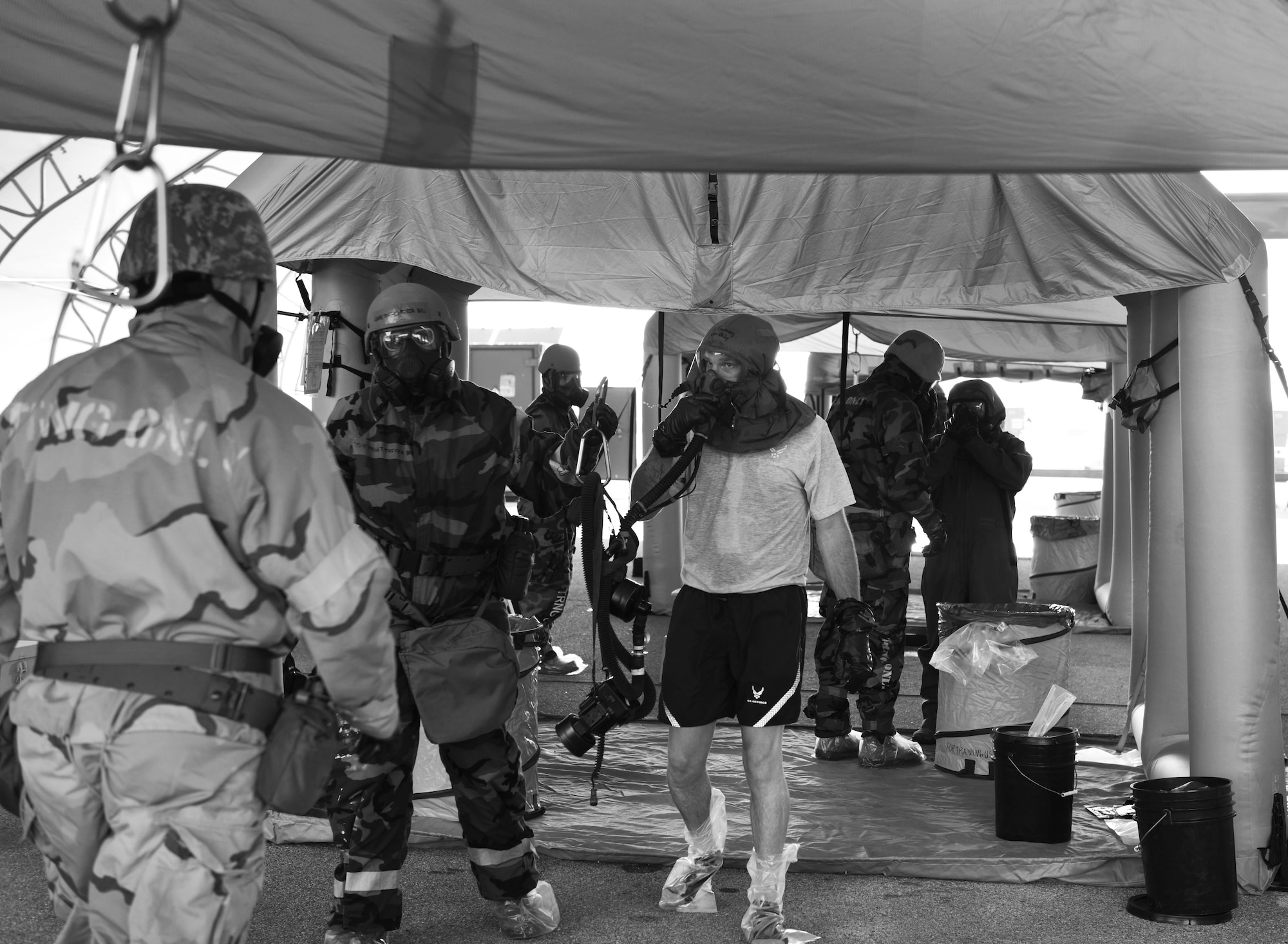 An aircrew flight equipment technician escorts an aircrew member through a Lightweight Inflatable Decontamination System in an Aircrew Contamination Control Area during exercise Toxic Arch at Scott Air Force Base, Ill., July 19. (U.S. Air Force photo by Staff Sgt. Stephenie Wade)