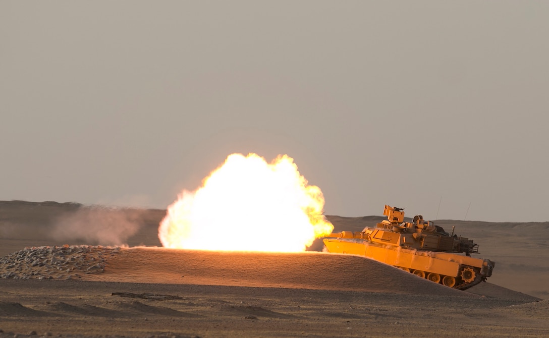 An M1A2 Abrams Main Battle Tank crew engages targets while providing direct fire support for a reconnaissance element during Hunter-Killer training at the Kuwait Multipurpose Range Complex June 7. Saber Squadron is developing Hunter-Killer as a concept, teaming Bradleys up with tanks for increased firepower and speed in the reconnaissance mission. (U.S. Army photo by Staff Sgt. Leah R. Kilpatrick/ released)