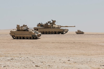 An M2A3 Bradley armored reconnaissance crew assigned to 6th Squadron, 9th Cavalry Regiment "Saber," 3rd Armored Brigade Combat Team, 1st Cavalry Division scans the terrain for "enemy" targets while an M1A2 Abrams Main Battle Tank crew provides direct fire support for the reconnaissance element during Hunter-Killer training at the Kuwait Multipurpose Range Complex June 7. Saber Squadron is developing Hunter-Killer as a concept, teaming Bradleys up with tanks for increased firepower and speed in the reconnaissance mission. (U.S. Army photo by Staff Sgt. Leah R. Kilpatrick/released)