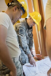 Staff Sgt. Justin Ming, an electrician with the 176th Civil Engineer Squadron, discusses renovation plans with his team in Latvia on July 25, 2017, at a children’s rehabilitation center. Thirty-six Alaska Air Guard members from the 176th CES and support units spent their two-week annual training as part of a humanitarian-civic assistance (HCA) project working alongside Latvian military and contractors to upgrade the aging building. 