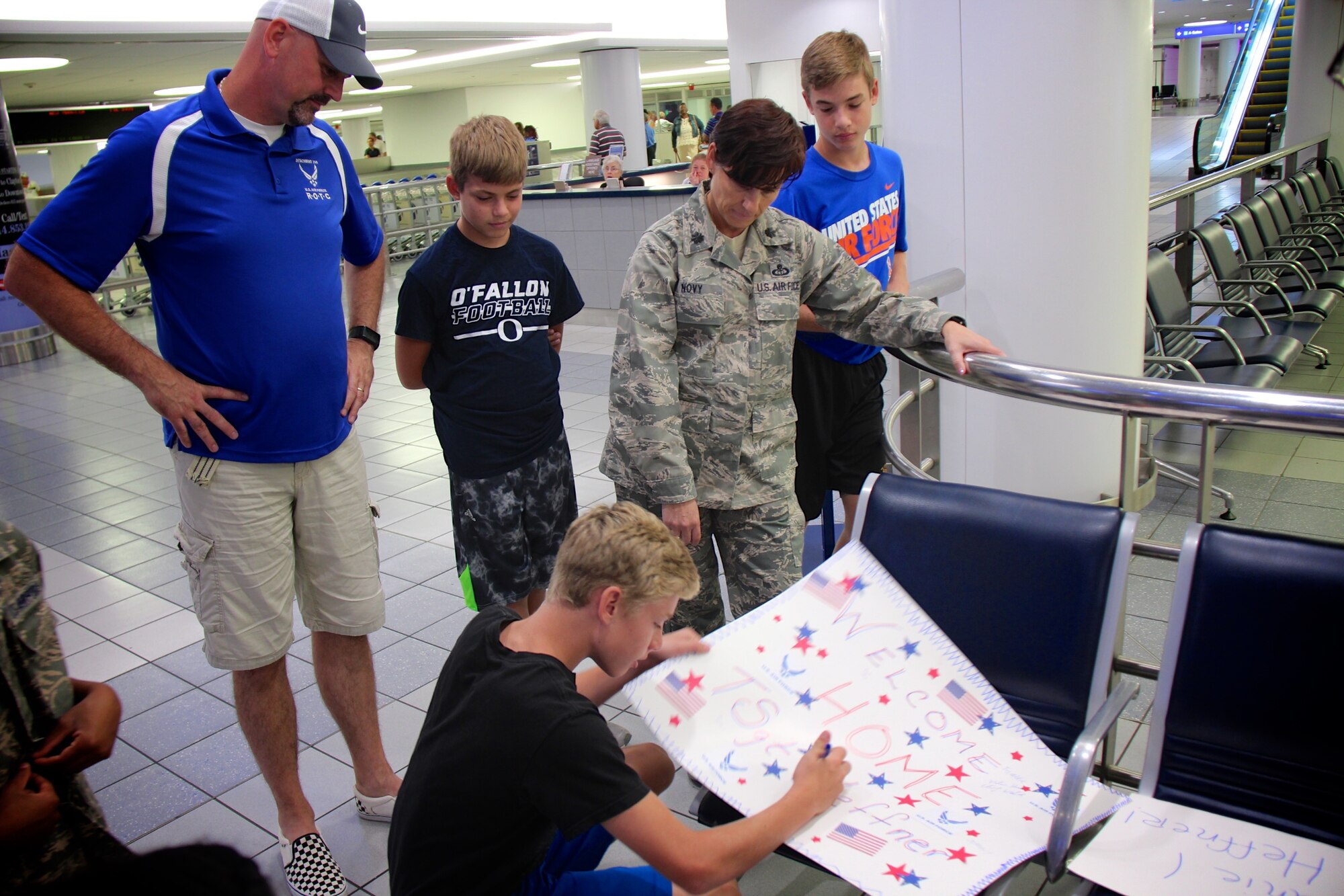 Director of Staff for the 932nd Airlift Wing, Lt. Col. Julie Novy and her family worked behind the scenes to create welcome home posters for an Airman returning from an overseas deployment.  The surprise visit to the airport amazed the unit member and was appreciated by his parents who witnessed the outpouring of support.  (U.S. Air Force photo by Lt. Col. Stan Paregien)