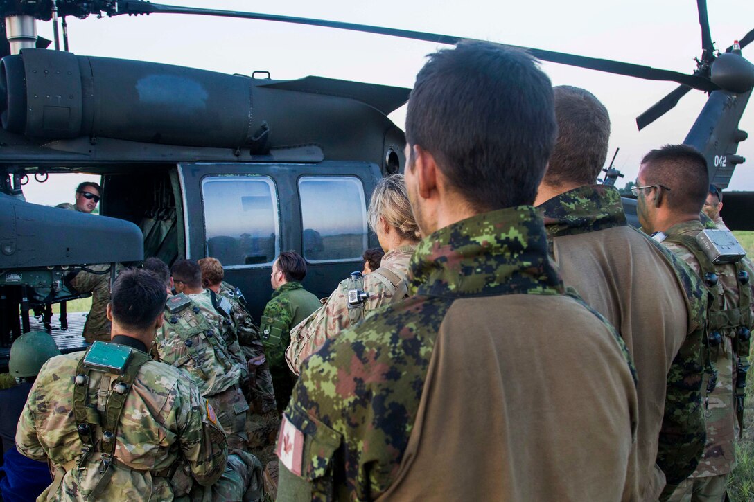 U.S. Army helicopter crew chiefs give a safety brief to U.S. and Canadian soldiers before participating in night air assault training during exercise Swift Response at Bezmer Air Base, Bulgaria, July 21, 2017. The exercise is part of Saber Guardian 17. Army photo by Spc. Thomas Scaggs