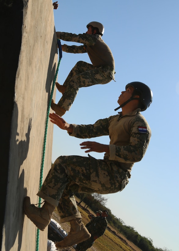 Paraguayan competitors run up a wall of an obstacle course event July 24, 2017, at Vista Alegre, Presidente Hayes, Paraguay. Paraguay is host to Fuerzas Comando 2017, the 13th iteration of a special operations competition designed to enhance multinational and regional cooperation, mutual trust and confidence, and to improve the training, readiness, interoperability, and capability of special forces. (U.S. Army photo by Staff Sgt. Chad Menegay/Released)