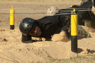 A Guyanese comando crawls beneath wires during a Fuerzas Comando obstacle course July 24, 2017, in Vista Alegre, Paraguay. This competition increases training knowledge and furthers interoperability between countries in the Western Hemisphere.  (U.S. Army photo by Sgt. Joanna Bradshaw/Released)