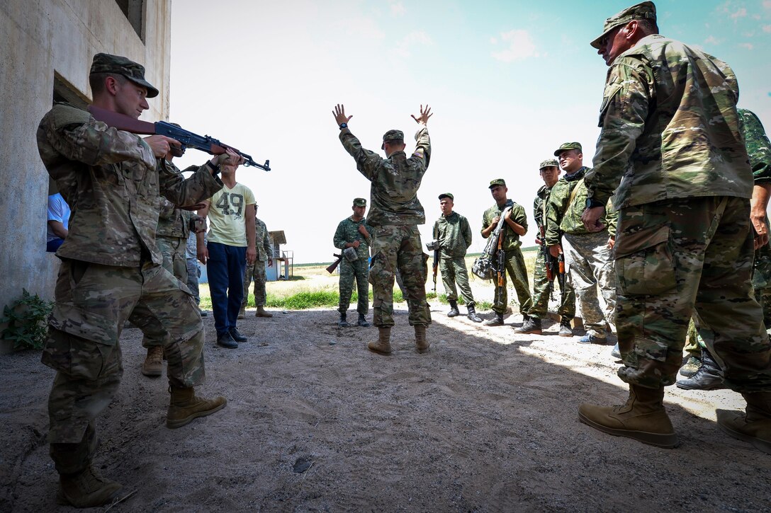 A soldier assigned to the 183rd Regiment, 1st Battalion, Virginia National Guard instructs a Tajik service member on searching procedures during a field training exercise that's part of multinational exercise Regional Cooperation 2017 in Fakhrabad, Tajikistan, July 17, 2017. Air Force photo by Staff Sgt. Michael Battles