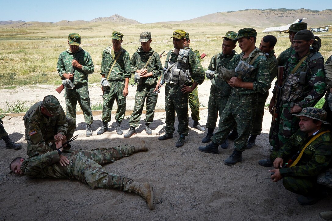 A soldier instructs a Tajik service member on search procedures during a field training exercise that's part of multinational exercise Regional Cooperation 2017 in Fakhrabad, Tajikistan, July 17, 2017. Air Force photo by Staff Sgt. Michael Battles