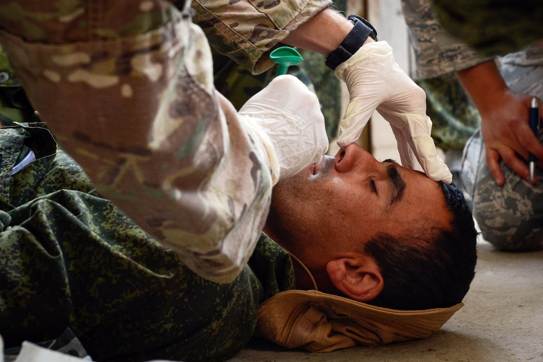 A Tajik service member prepares to receive a nasopharyngeal insert during a field training exercise that's part of multinational exercise Regional Cooperation 2017 in Fakhrabad, Tajikistan, July 17, 2017. Air Force photo by Staff Sgt. Michael Battles