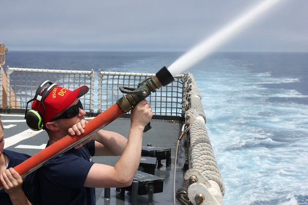 Damage Control Chief David Warner trains shipmates on hose handling techniques.