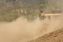 U.S. Army Reserve Sgt. John Brownlee, a Horizontal Construction Engineer assigned to the 718th Engineer Company, based in Fort Benning, Ga., is covered in a cloud of smoke while overseeing operations to improve a berm for a fuel blivet, a collapsible tank, emplacement during Combat Support Training Exercise 91-17-03, July 18, 2017, at Fort Hunter Liggett, Calif. Approximately 5,000 Army Reserve and National Guard forces participated in the exercise. First Army provided about 65 observer coach/trainers to augment their Army Reserve partners at the 91st Training Division and assist in training the most capable, combat-ready and lethal federal reserve force in the history of the nation. 
(U.S. Army photo by Master Sgt. Anthony L. Taylor)