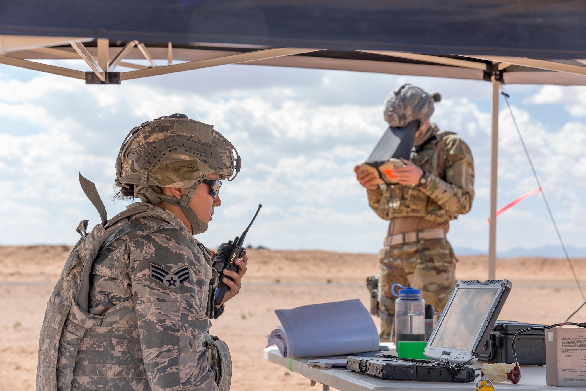 Senior Airman Alexandra Haytasingh (left) and Airman 1st Class Jedidiah Burlando work together to navigate the RQ-11B Raven DDL during the first training qualification program on the unmanned aircraft system for the Air Force at McGregor Range, N.M., July 6.