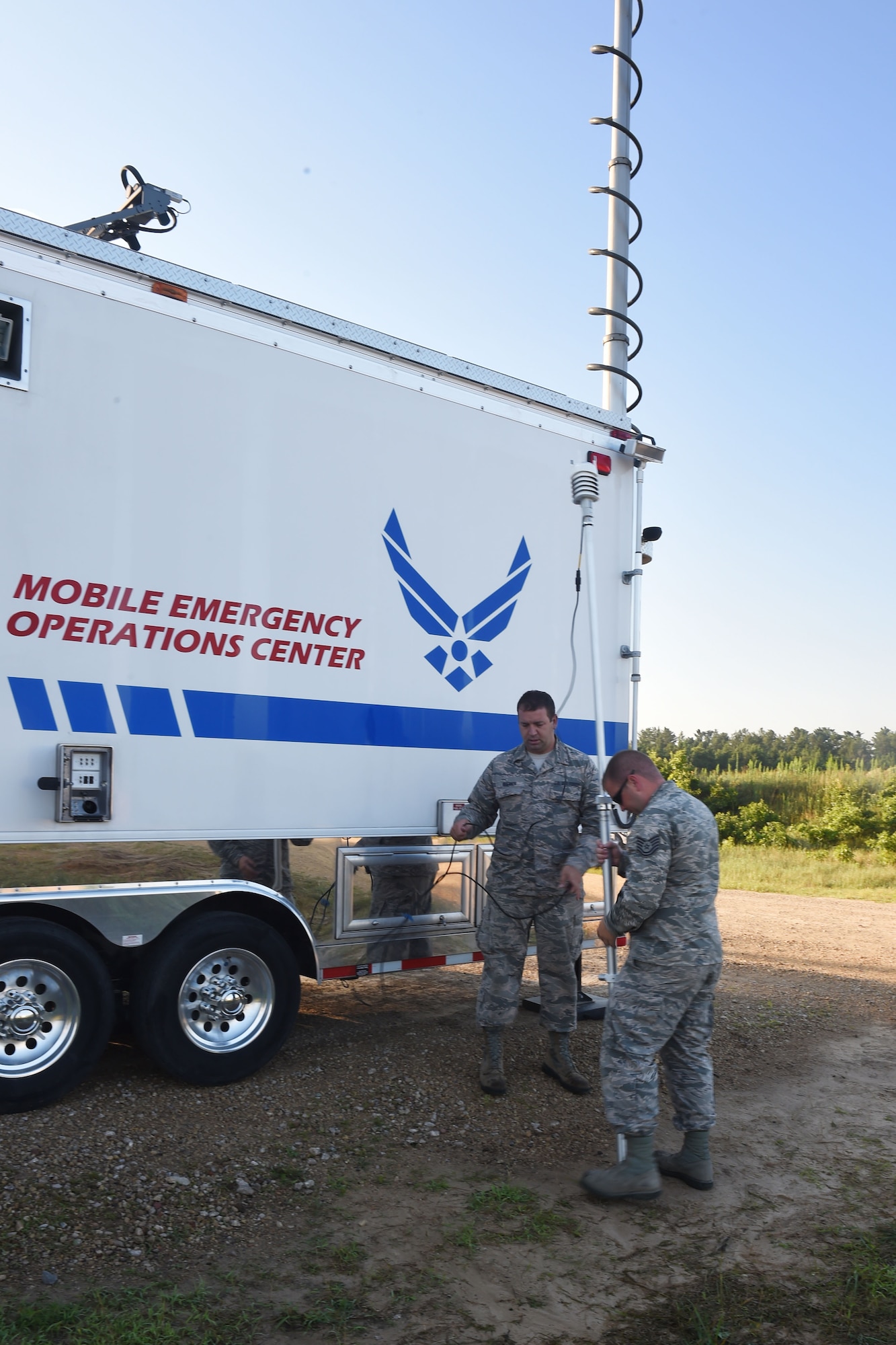Tech. Sgt. Joeseph Stickel, a Cyber Transportation technician, and Master Sgt. Brad Kuennen, a Radio Frequency Transmissions Systems technician, place the weather station for the 132d Wing's Mobile Emergency Operations Center (MEOC) on July 19, 2017 at Fort McCoy, Wis. The weather station provides numbers for wind direction and temperature, among other things, so that Stickel and Kuennen can monitor weather conditions in support of PATRIOT North 2017. (Air National Guard photo by A1C Katelyn Sprott)