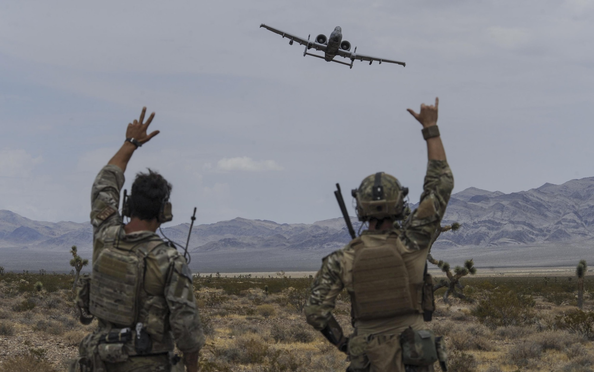 Joint terminal attack controllers wave at an A-10 Thunderbolt II attack aircraft during a show of force on the Nevada Test and Training Range July 19, 2017. The A-10 has excellent maneuverability at low air speeds and low-altitude, and is a highly accurate weapons delivery platform. (U.S. Air Force photo by Senior Airman Kevin Tanenbaum/Released)