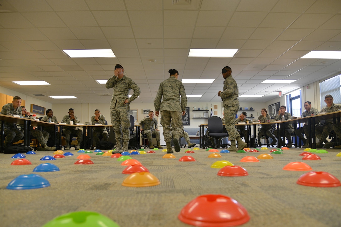 U.S. Air Force Airmen enrolled in the First Term Airman Course participate in a mine field exercise at Joint Base Langley-Eustis, Va., July 21, 2017. During the team-building exercise, the students worked together to navigate across the classroom in a simulated mine field.