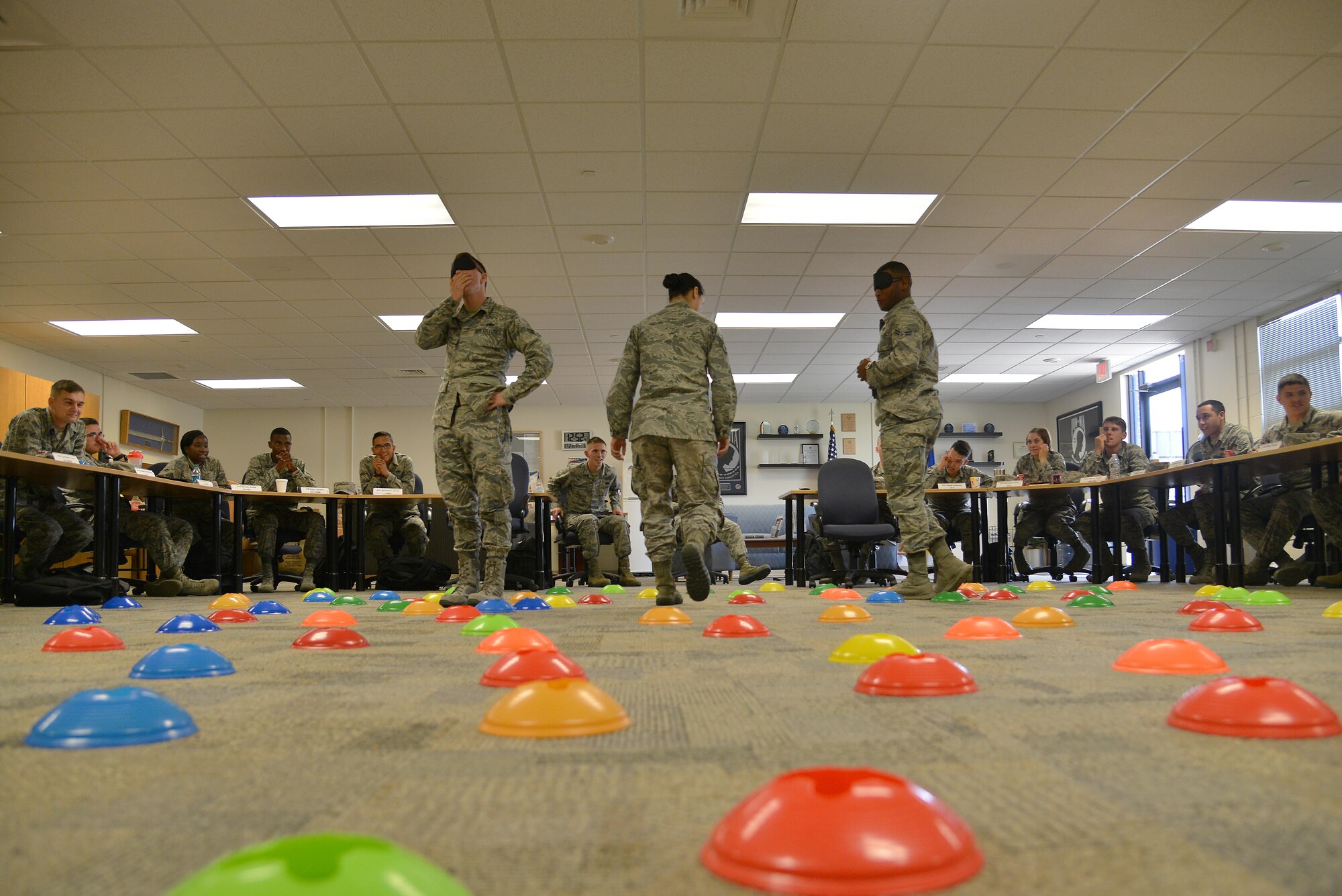 U.S. Air Force Airmen enrolled in the First Term Airman Course participate in a mine field exercise at Joint Base Langley-Eustis, Va., July 21, 2017. During the team-building exercise, the students worked together to navigate across the classroom in a simulated mine field.