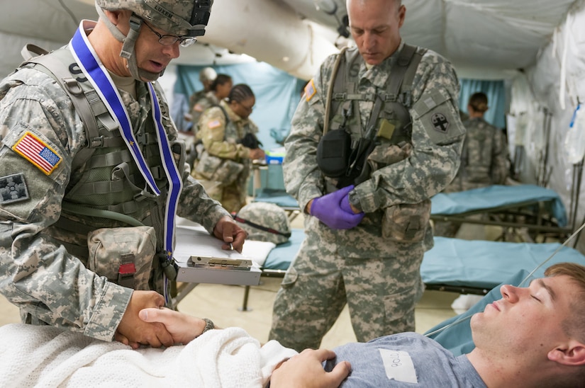 U.S. Army Capt. Tony M. Luxem, chief hospital clinician and chaplain for the 47th Combat Support Hospital out of Joint Base Lewis-McChord, Washington, prays with a patient in the Minimal Care Detachment section of the Combat Support Hospital on Camp Roberts, California, July 18, 2017. The CSH is part of the 84th Training Command’s Combat Support Training Exercise and the Army Medical Command’s Global Medic Exercise headquartered out of Fort Hunter Liggett, California. (U.S. Army Reserve photo by Spc. Miguel Alvarez, 354th Mobile Public Affairs Detachment)