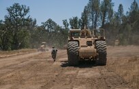 Sgt. Robert Burns, a squad leader with the 718th Engineer Company, moves from speaking with the driver of a scraper to the driver of a grader. Burns was acting as the platoon leader after the actual platoon leader was notionally eliminated in combat with opposing forces. Nearly 5,400 service members from the U.S. Army Reserve Command, U.S. Army, Army National Guard, U.S. Navy, and Canadian Armed Forces are training at Fort Hunter Liggett as part of the 84th Training Command’s CSTX 91-17- 03 and ARMEDCOM’s Global Medic; this is a unique training opportunity that allows U.S. Army Reserve units to train alongside their multicomponent and joint partners as part of the America’s Army Reserve evolution into the most lethal Federal Reserve force in the history of the nation. (U.S. Army Reserve photo by Sgt. David L. Nye, 301st Public Affairs Detachment)
