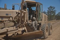 Sgt. Robert Burns, a squad leader with the 718th Engineer Company, speaks with Spc. Lebron Luis, a horizontal engineer with the 718th, as Luis uses a grader to complete a drainage ditch near the 718th's temporary motor pool during training at Fort Hunter Liggett on July 19, 2017. Nearly 5,400 service members from the U.S. Army Reserve Command, U.S. Army, Army National Guard, U.S. Navy, and Canadian Armed Forces are training at Fort Hunter Liggett as part of the 84th Training Command’s CSTX 91-17- 03 and ARMEDCOM’s Global Medic; this is a unique training opportunity that allows U.S. Army Reserve units to train alongside their multi-component and joint partners as part of the America’s Army Reserve evolution into the most lethal Federal Reserve force in the history of the nation. (U.S. Army Reserve photo by Sgt. David L. Nye, 301st Public Affairs Detachment)