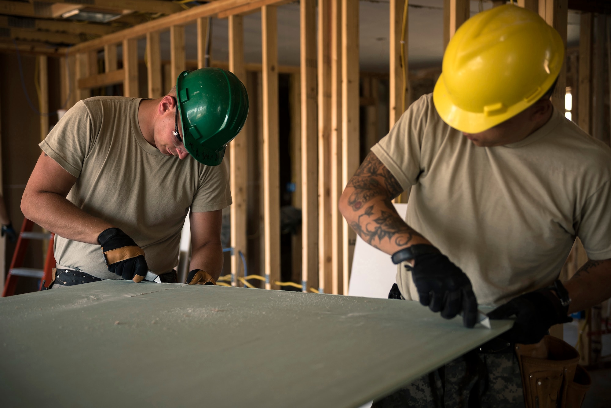 U.S. Army Staff Sgt. Stevn Henke, left, a section sergeant, and Spc. Dan Rose, a concrete and masonry specialist, both with the 230th Vertical Engineer Company, Montana Army National Guard, cut drywall in Crow Agency, Mont., July 24, 2017. The soldiers teamed up with the Illinois Air National Guard’s 182nd Civil Engineer Squadron to help build homes for Native American veterans as part of the Department of Defense’s Innovative Readiness Training civil-military relations program. (U.S. Air National Guard photo by Tech. Sgt. Lealan Buehrer)