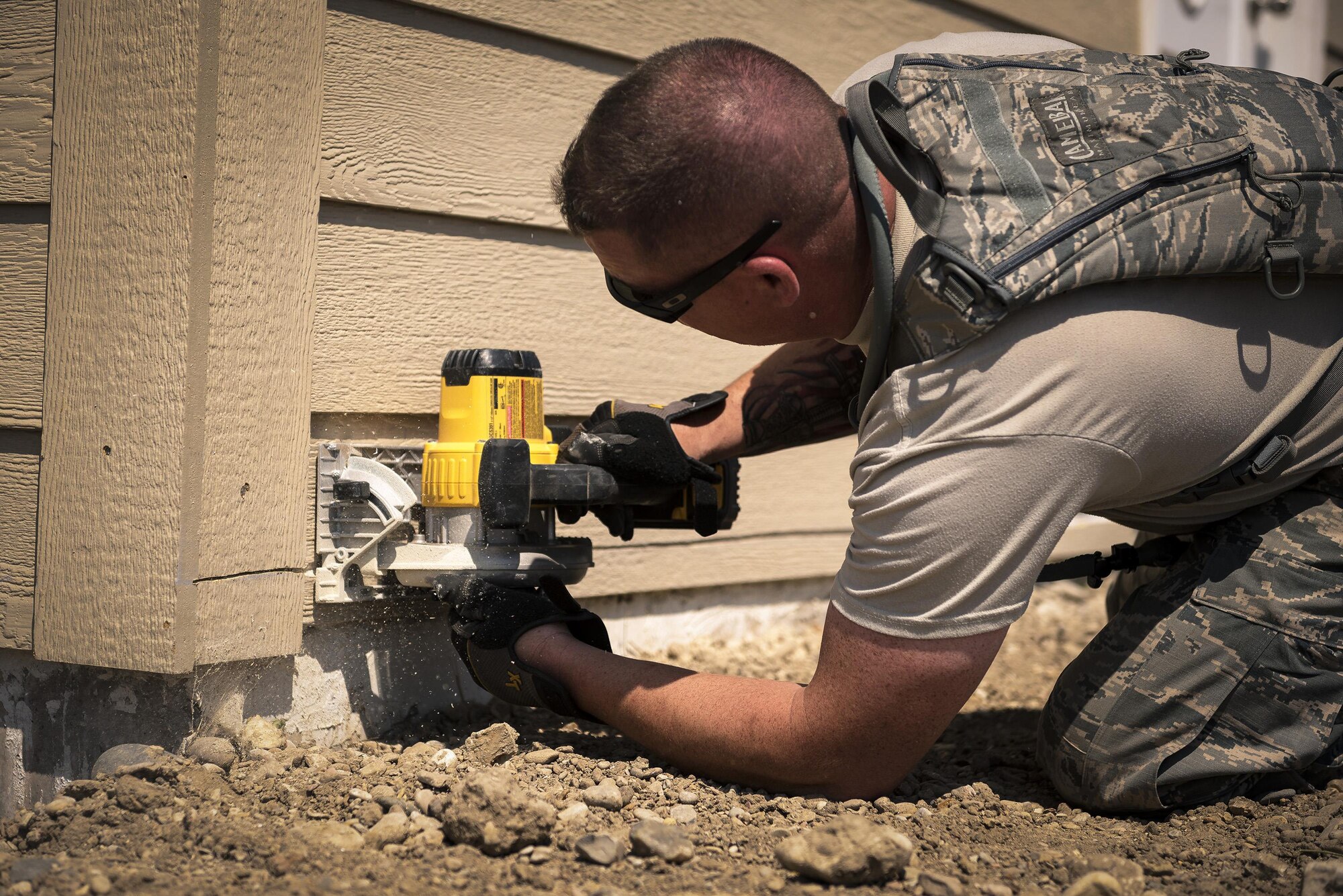 U.S. Air Force Staff Sgt. Christopher Boen, a pavement and construction equipment specialist with the 182nd Civil Engineer Squadron, Illinois Air National Guard, trims siding during annual training in Crow Agency, Mont., July 24, 2017. The squadron helped build homes for Native American veterans as part of the Department of Defense’s Innovative Readiness Training civil-military relations program. (U.S. Air National Guard photo by Tech. Sgt. Lealan Buehrer)