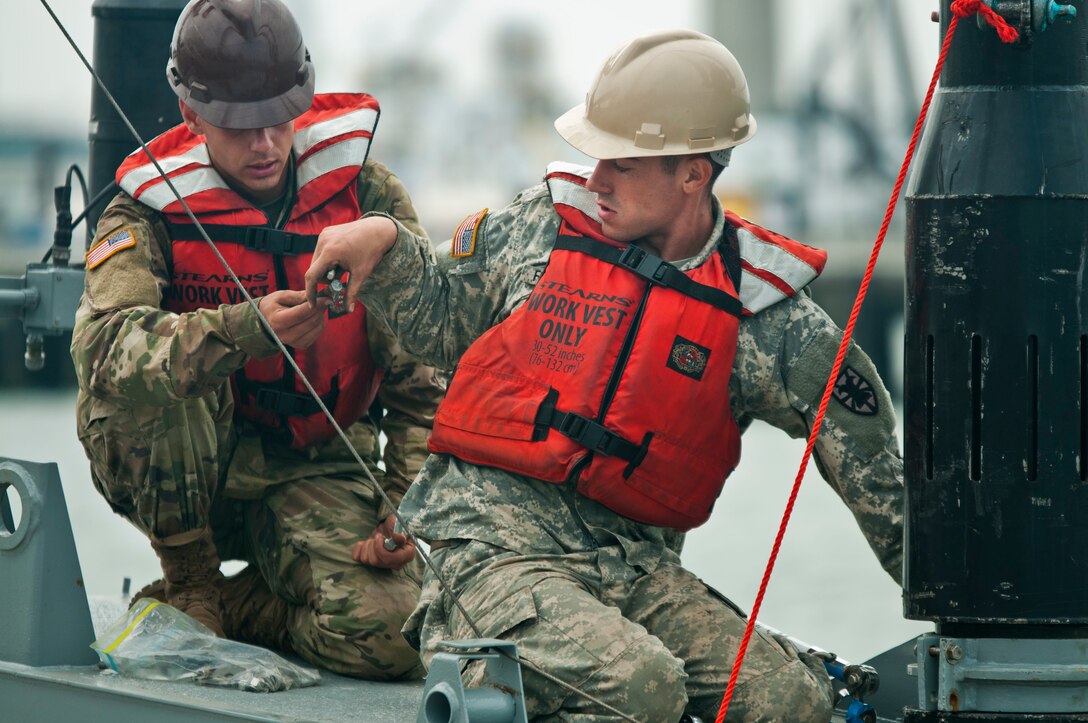 Pfc. Zach Figueroa, a member of the 331st Transportation Company, takes a bolt from Pvt. Michael Grella, also with the 331st, while reassembling a modular warping tug in the Port of San Diego during training on July 16, 2017, in support of an engineering project to construct a causeway. The causeway is used to quickly move supplies from ships to shore. U.S. Army Reserve Command Soldiers are participating in Exercise Big LOTS West, a joint military training exercise designed to reinforce the 1394th Transportation Brigade's ability to rapidly deploy vital combat equipment to an operational environment. (Photo by U.S. Army Reserve Sgt. David L. Nye, 301st Public Affairs Detachment)