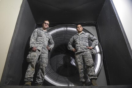 Staff Sgt. Joshua Barr, left, and Airman 1st Class Brandon Gross, right, 628th Civil Engineer Squadron heating, ventilation and air conditioning technicians, help maintain the heating and cooling systems on Joint Base Charleston, S.C., July 25. One of the major facilities they maintain is the ventilation systems for the installation’s corrosion control facility. Also, ventilating the paint hangar ensures toxic fumes aren’t breathed in by the members working in the facility.
