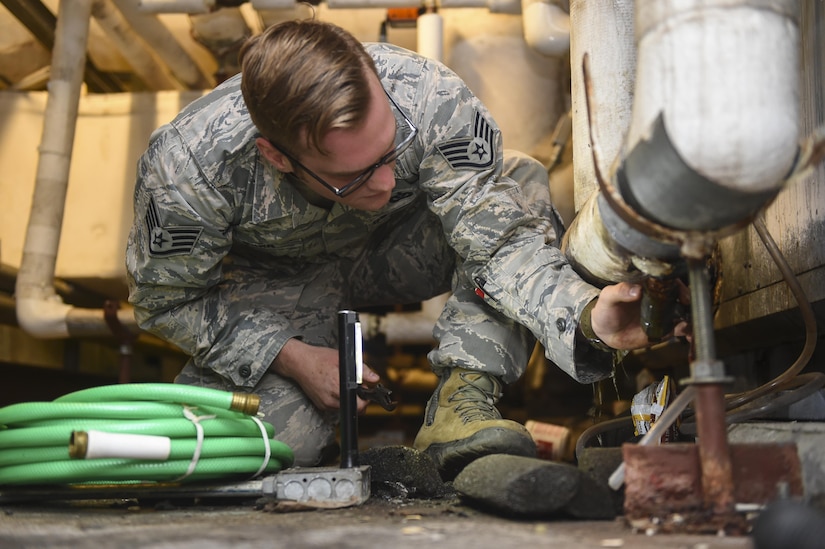 Staff Sgt. Joshua Barr, 628th Civil Engineer Squadron heating, ventilation and air conditioning technician, drains excess water from a coolant system in a dormitory building on Joint Base Charleston, S.C., July 25. HVAC is responsible for maintaining proper temperatures for some of the base’s most important systems.