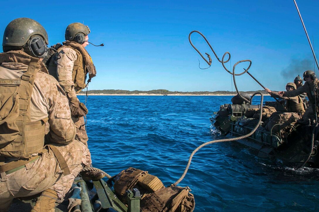 Marine Corps Lance Cpl. Mason J. Blankenship tosses a rope from one assault amphibious vehicle to another during water recovery training off the coast of Freshwater Beach at the Shoalwater Bay training area in Australia, July 22, 2017, as part of Exercise Talisman Saber 17. Talisman Saber is a biennial exercise designed to improve interoperability between Australian and U.S. forces. Marine Corps photo by Cpl. Amaia Unanue