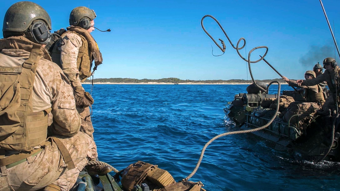 Marine Corps Lance Cpl. Mason J. Blankenship tosses a rope from one assault amphibious vehicle to another during water recovery training off the coast of Freshwater Beach at the Shoalwater Bay training area in Australia, July 22, 2017, as part of Exercise Talisman Saber 17. Talisman Saber is a biennial exercise designed to improve interoperability between Australian and U.S. forces. Marine Corps photo by Cpl. Amaia Unanue