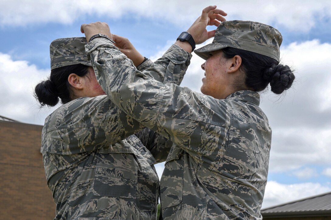 Lakota Hull, left, and her identical twin, Raven Hull, fix each other's hats in Mansfield, Ohio, July 25, 2017. Both are assigned to the Ohio Air National Guard’s 179th Airlift Wing. Air Force photo by Airman 1st Class Christi Richter