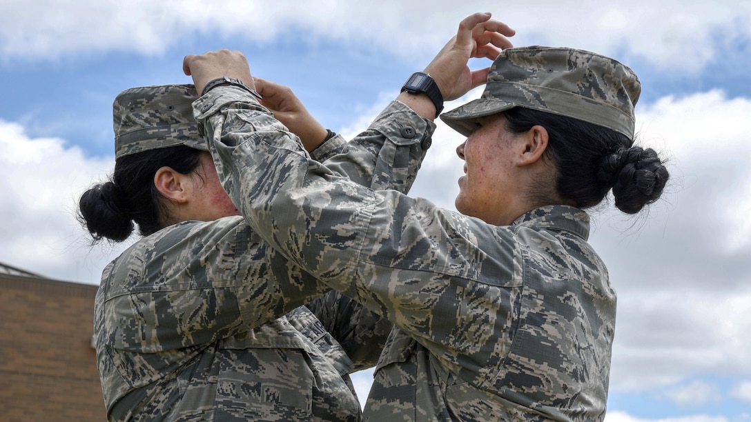 Lakota Hull, left, and her identical twin, Raven Hull, fix each other's hats in Mansfield, Ohio, July 25, 2017. Both are assigned to the Ohio Air National Guard’s 179th Airlift Wing. Air Force photo by Airman 1st Class Christi Richter