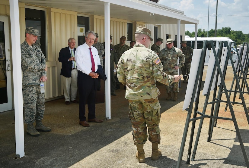 U.S. Army Lt. Col. Kenneth Hoisington, center, U.S. Army Logistics Activity Charleston director, provides a mission briefing for Charleston Mayor John Tecklenburg, left, and Joint Base Charleston leadership at the Weapons Station  during a site visit here, July 25. The locations Tecklenburg toured included the Naval Health Clinic Charleston, the Naval Nuclear Power Training Command and the 841st Transportation Battalion. Tecklenburg was selected to represent the installation at the Joint Civilian Orientation Conference in August 2017. The mission of JCOC is to increase public understanding of national defense by enabling American business and community leaders to directly observe and engage with the U.S. military. 