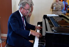 Charleston Mayor John Tecklenburg, plays the piano for Joint Base Charleston leadership during a mission briefing inside the Naval Health Clinic Charleston here, July 25. The locations Tecklenburg toured included Naval Health Clinic Charleston, the Naval Nuclear Power Training Command and the 841st Transportation Battalion. Tecklenburg was selected to represent the installation at the Joint Civilian Orientation Conference in August 2017. The mission of JCOC is to increase public understanding of national defense by enabling American business and community leaders to directly observe and engage with the U.S. military. 