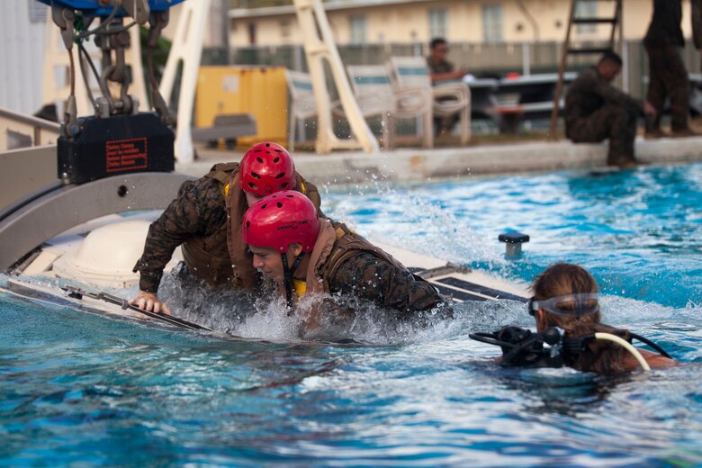 U.S. Marines assigned to 3rd Marine Regiment, 3rd Marine Division, escape a Submerged Vehicle Egress Trainer (SVET) during Underwater Egress Training (UET), Marine Corps Base Hawaii, July 21, 2017. In the event of an Amphibious Assault Vehicle sinking, SVET and UET are vital training programs that prepares Marines and Sailors on safely escaping the vehicle. (U.S. Marine Corps photo by Lance Cpl. Matthew Kirk)