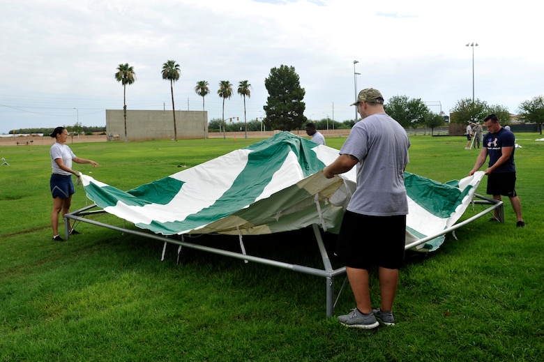 A team of Thunderbolts prepare to finish the top housing of a canopy tent July 25, 2017. The Back-to-School Bash is held annually as the school summer comes to an end.  (U.S. Air Force photo/Airman 1st Class Pedro Mota) 